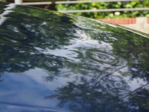 A car with a dented hood from a hail storm.